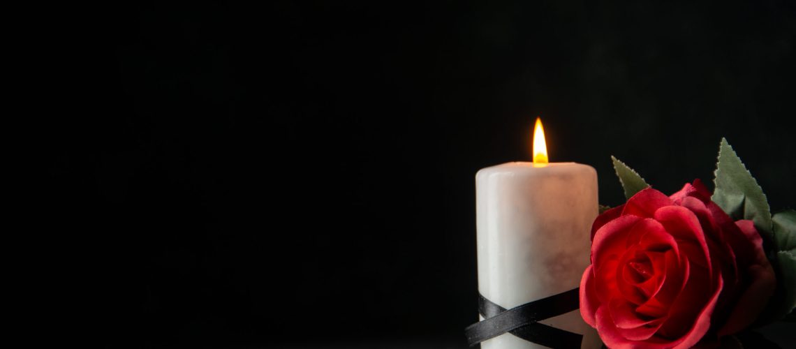 front-view-white-candles-with-red-flower-dark-wall